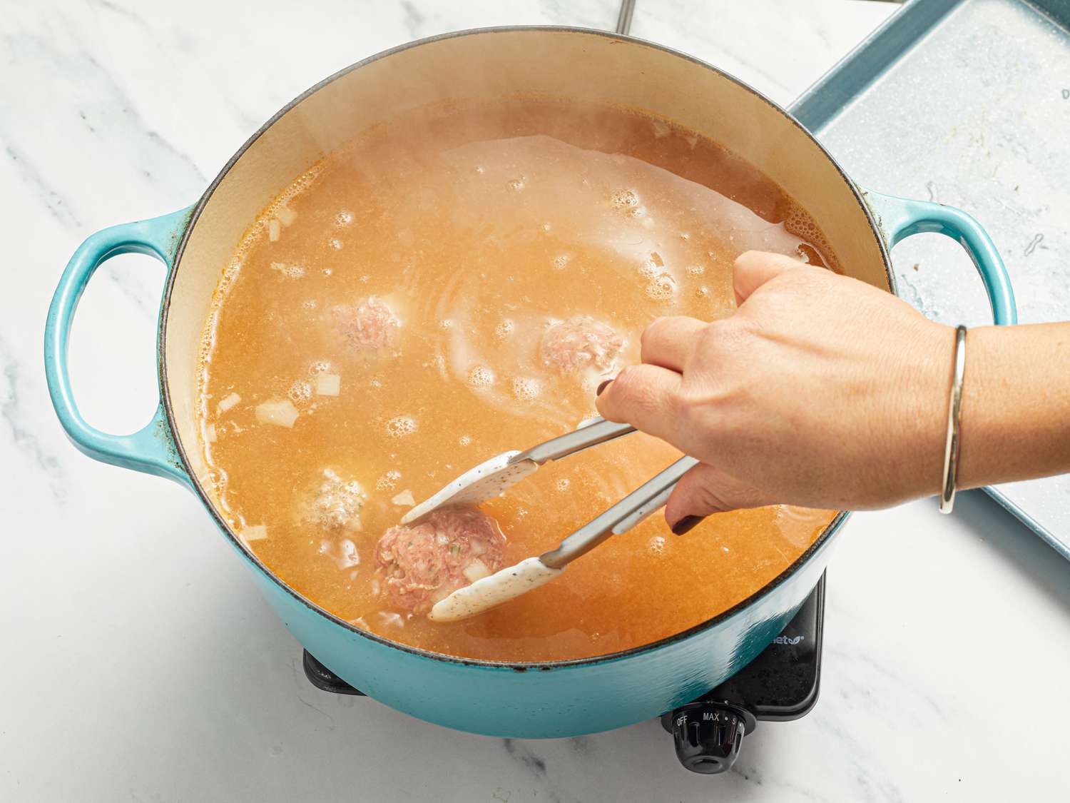 Adding meatballs to broth in dutch oven