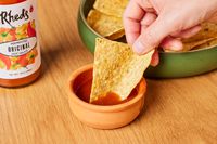 The Rhed's house sauce on a countertop with tortilla chips.