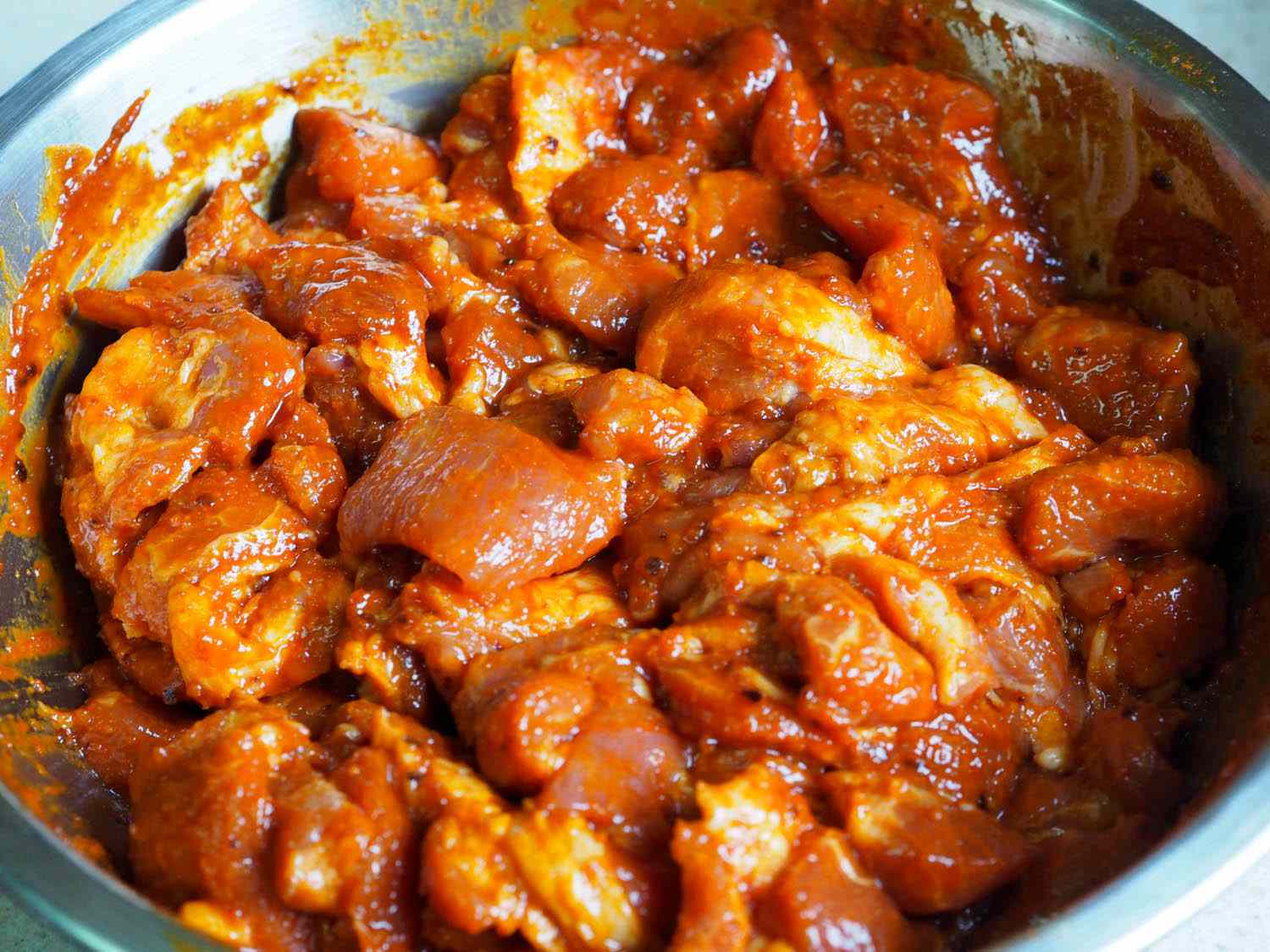 Strips of pork shoulder are combined with the marinade.