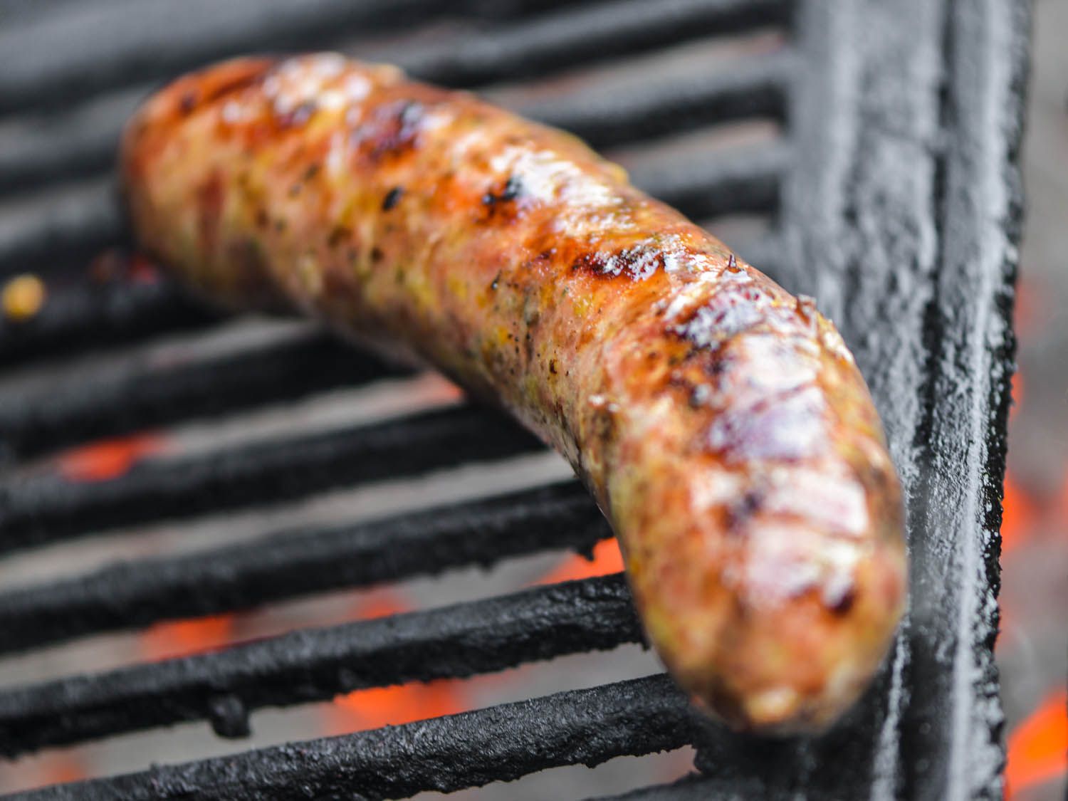 Orange and leek loukaniko sausage browning nicely on a grill.