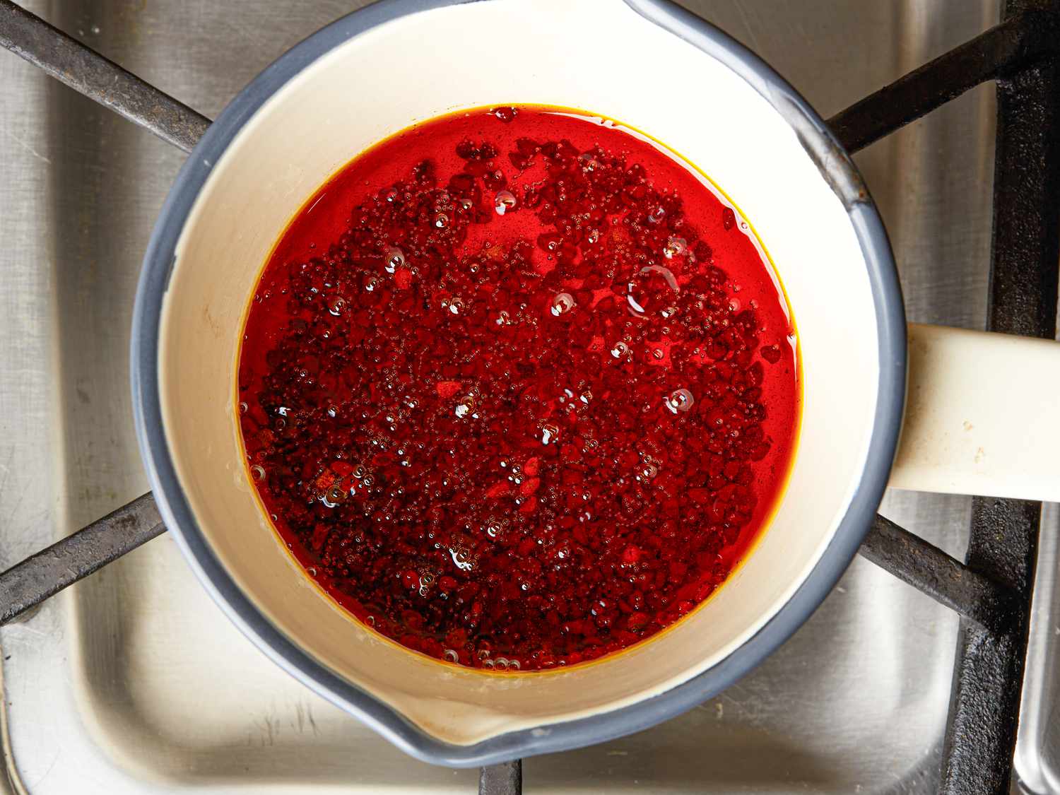 Overhead view of heating annatto seeds in oil