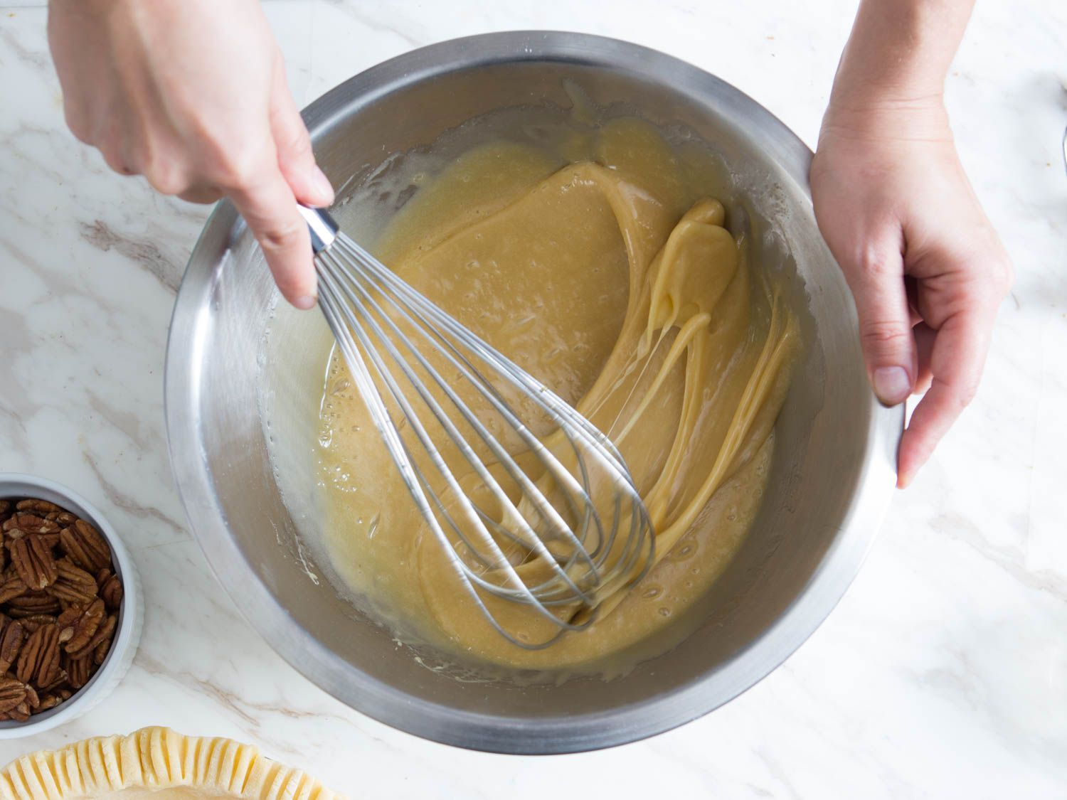 Whisking the ingredients for pecan pie, including: eggs, honey, corn syrup, brown sugar, melted butter, salt, and vanilla.