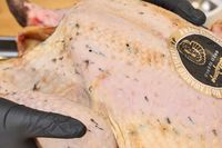 A close up of the skin of the raw KellyBronze Turkey