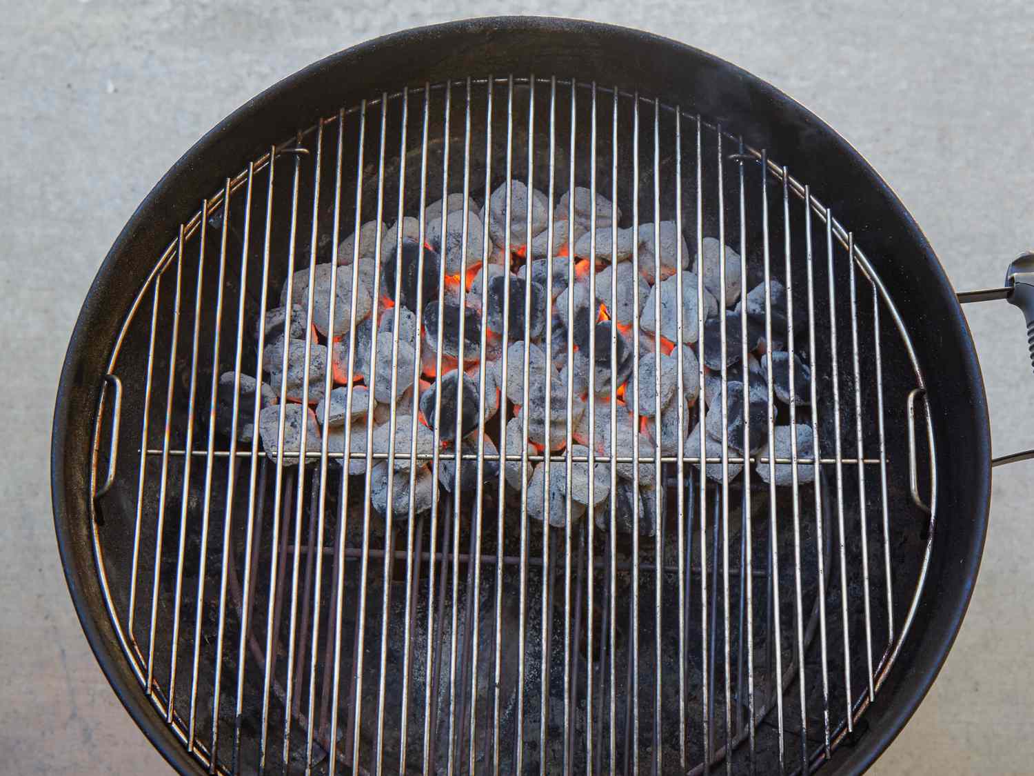 A grill with hot coals glowing beneath the cooking grates