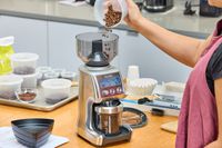 A person pours coffee beans into the Breville The Smart Grinder Pro