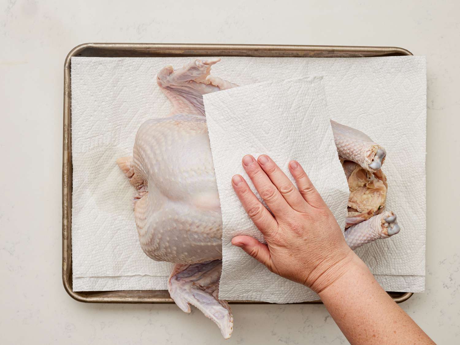 Overhead view of patting turkey dry