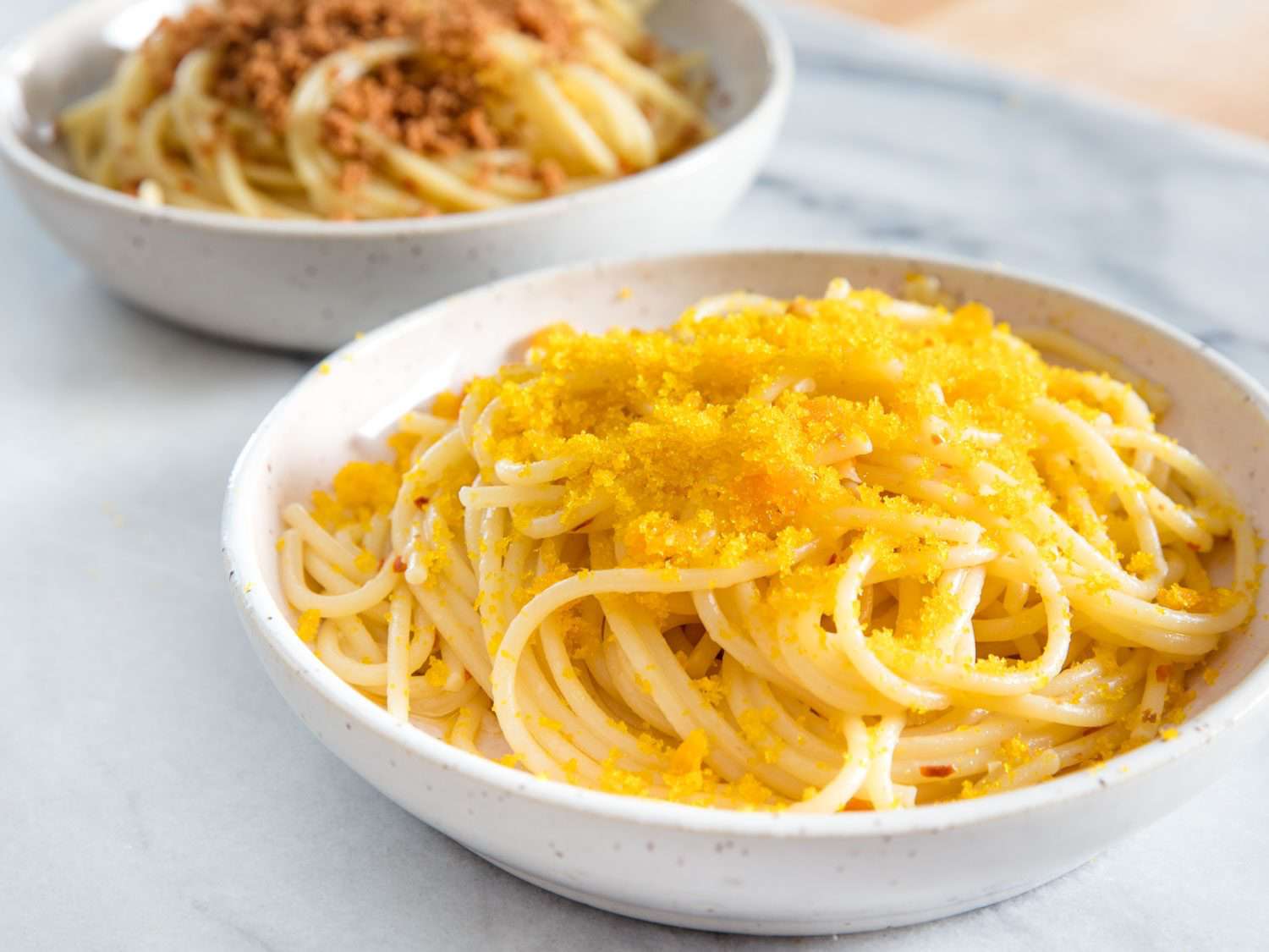 Bottarga grated over a bowl of spaghetti.