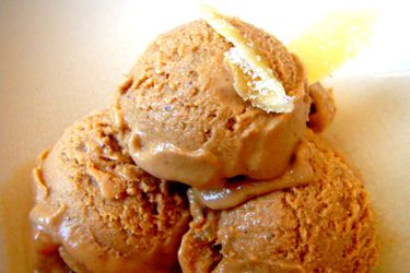 Closeup of three scoops of Trappist ale and gingerbread ice cream in a white bowl.