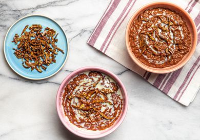 Overhead view of two bowls of Champorado and a side plate of candied anchovies