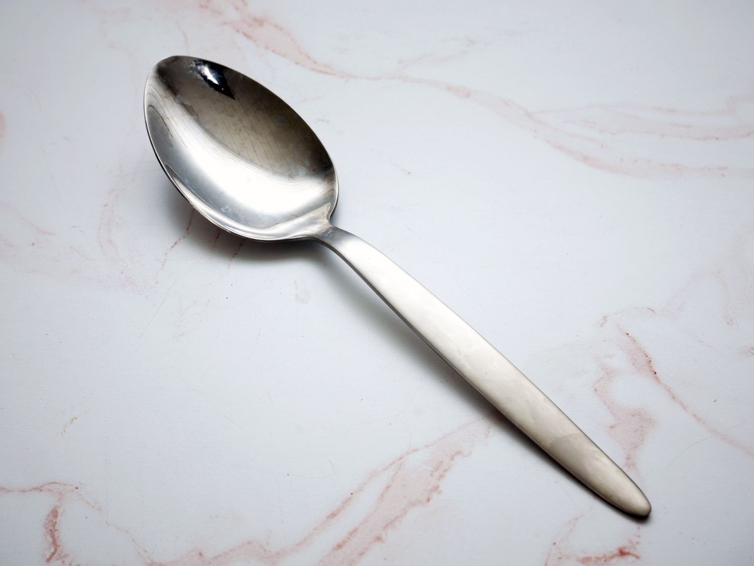 the j.b. prince kunz sauce spoon on a pink marble surface