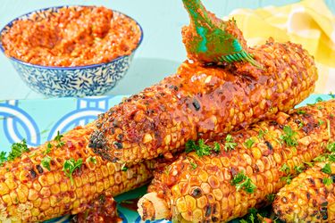 Grilled corn on the cob brushed with paprika and harissa butter