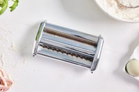 Cutter attachment for pasta machine on white surface