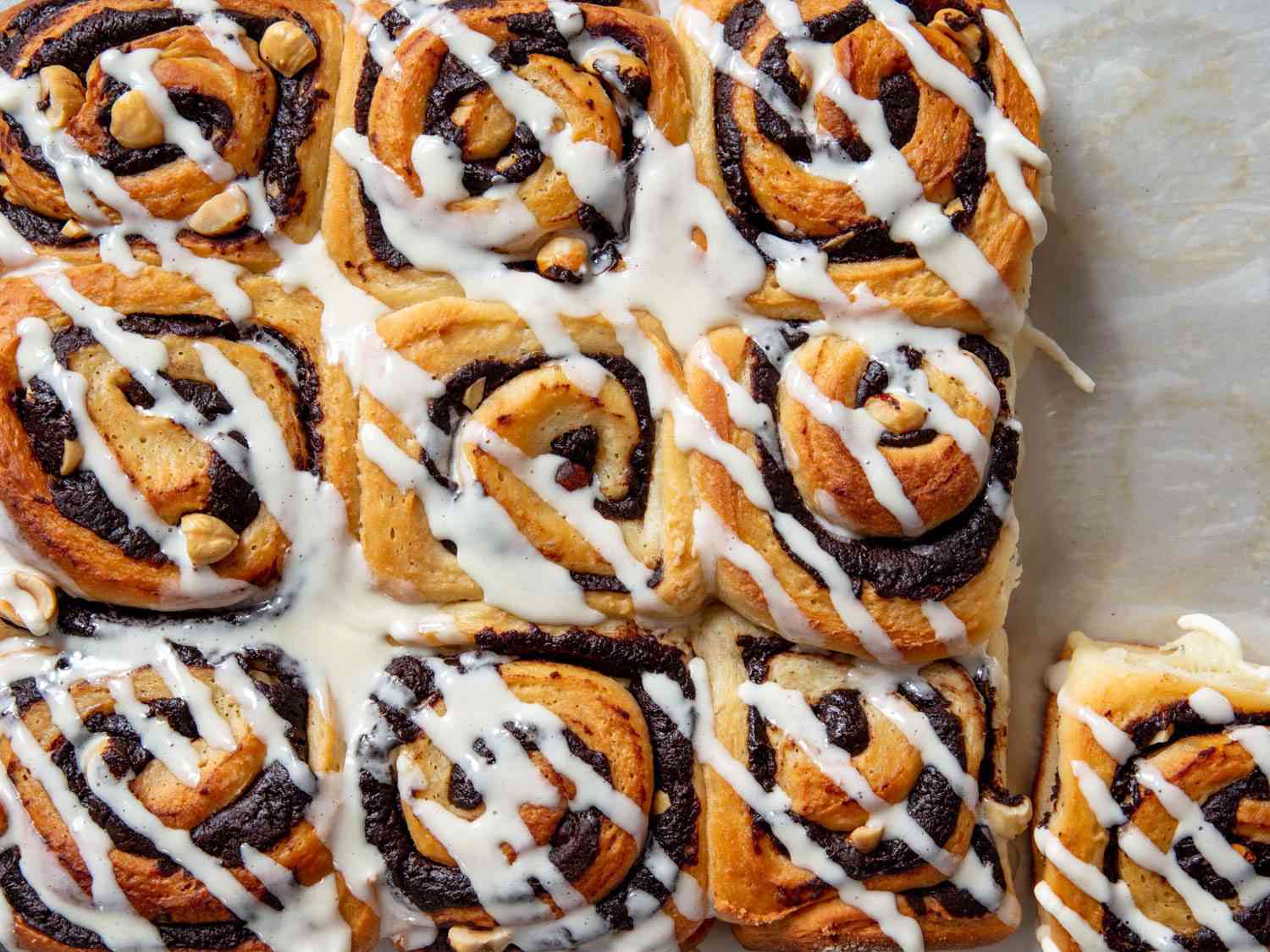 a tray of chocolate hazelnut buns drizzled with frosting