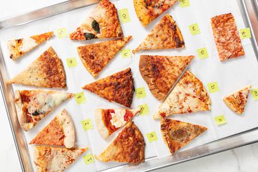 Several different types of frozen pizza on a parchment paper lined sheet pan with numbers next to them 