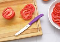 the victorinox knife on a wooden cutting board with sliced tomatoes