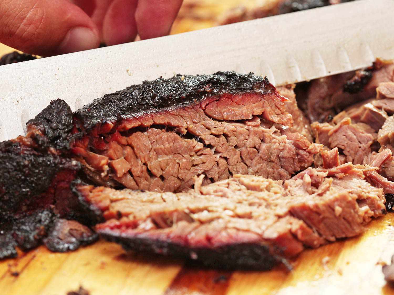 Cutting smoked chuck roll into thin slices.