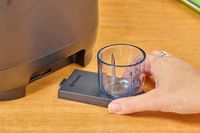 A hand holding a part to to the Vitamix Ascent X5 Blender