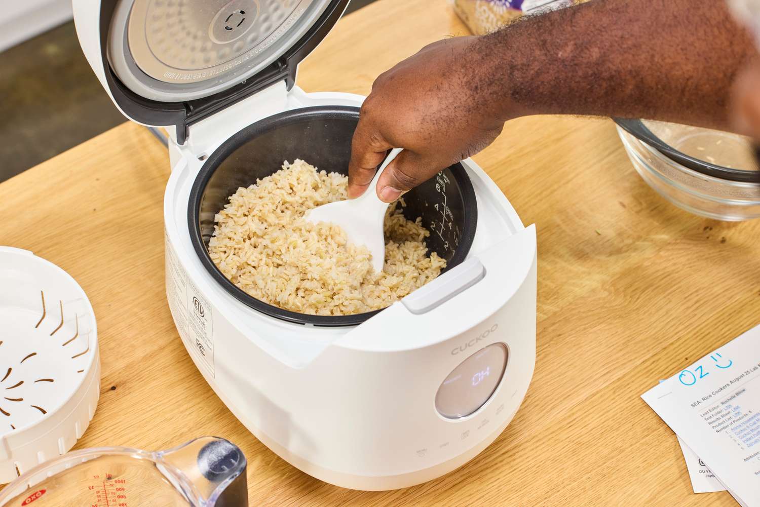 A person scoops rice from the Cuckoo 6-Cup Micom Rice Cooker