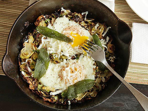 Brussels Sprouts Hash With Fried Sage and Soft Cooked Eggs in a cast iron skillet.