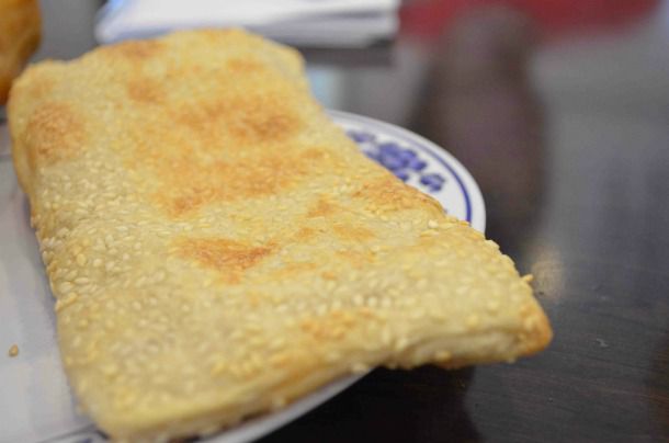 Closeup of a baked wheat cake (shao bing) served on a plate.