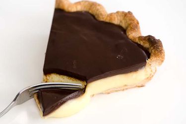 Digging into a slice of Boston Cream Pie with a fork