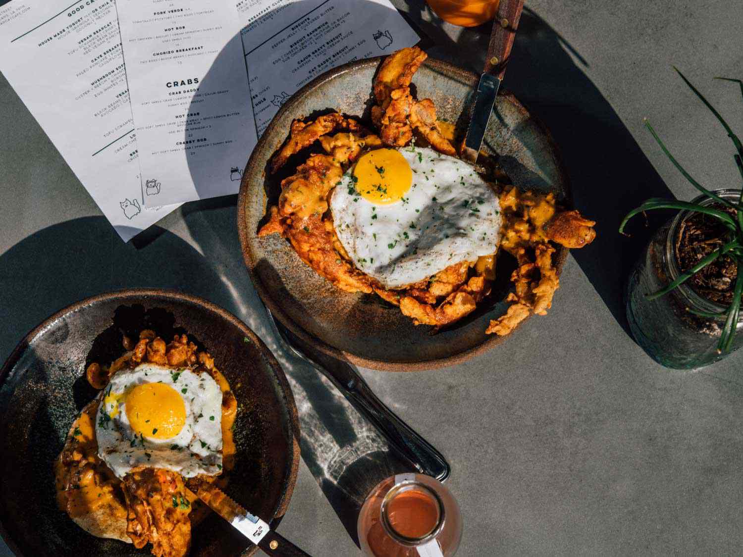 The "Crab Daddy" at Bearcat Cafe: biscuits, fried crab, and a fried egg on a table with drinks and menus.