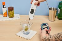 Person putting thermometer in Libbey Cosmopolitan Stemless Glass 