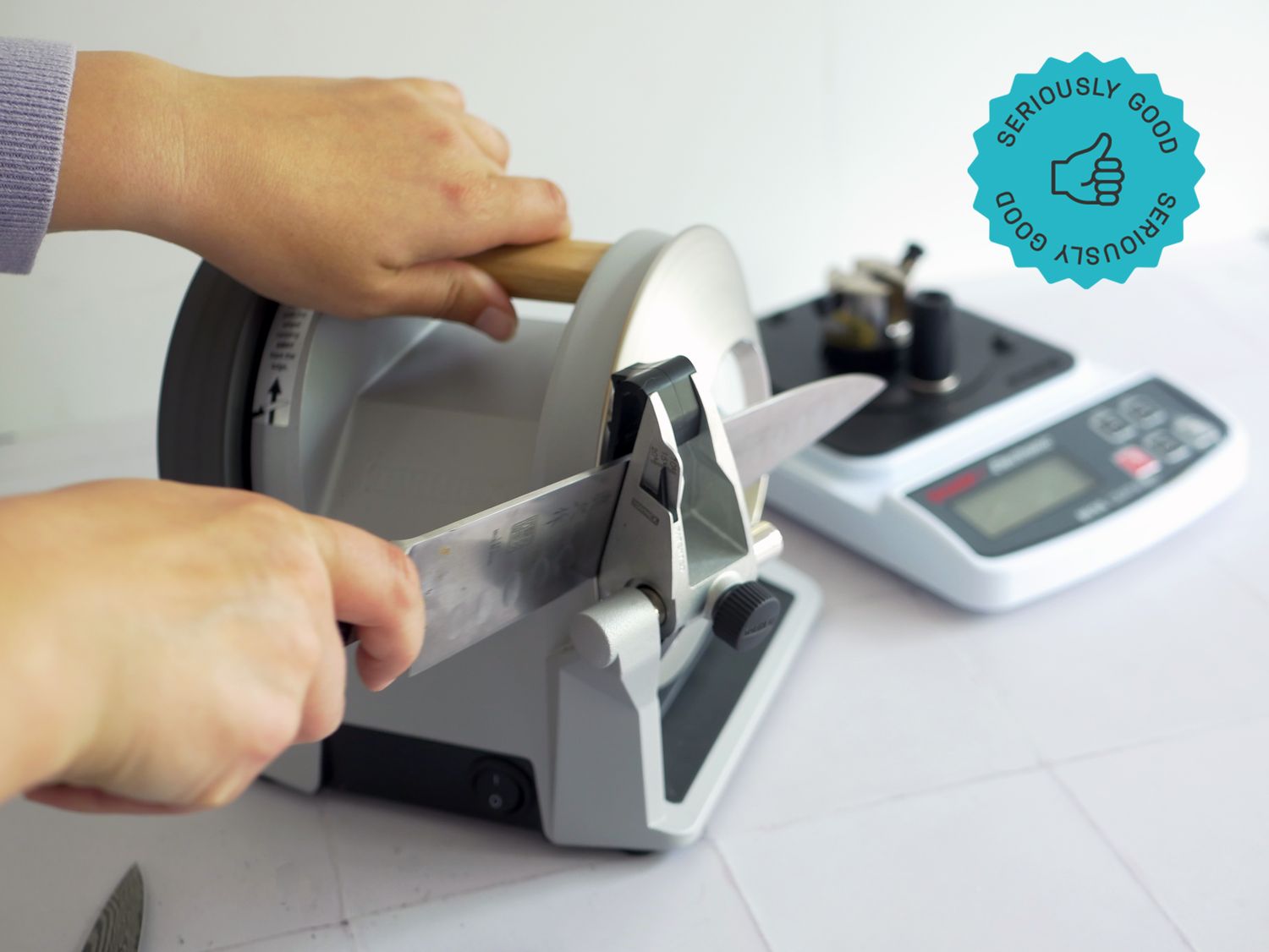 a person using the tormek knife sharpener to sharpen a chef's knife
