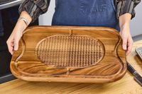 Person holding a Lipper International Acacia Cutting Board with Grid Grip