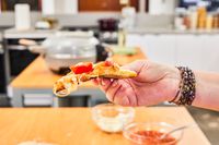A person holding a slice of pizza.