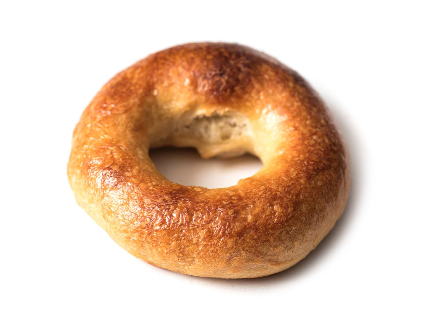A bagel with a blow out on the interior crust.