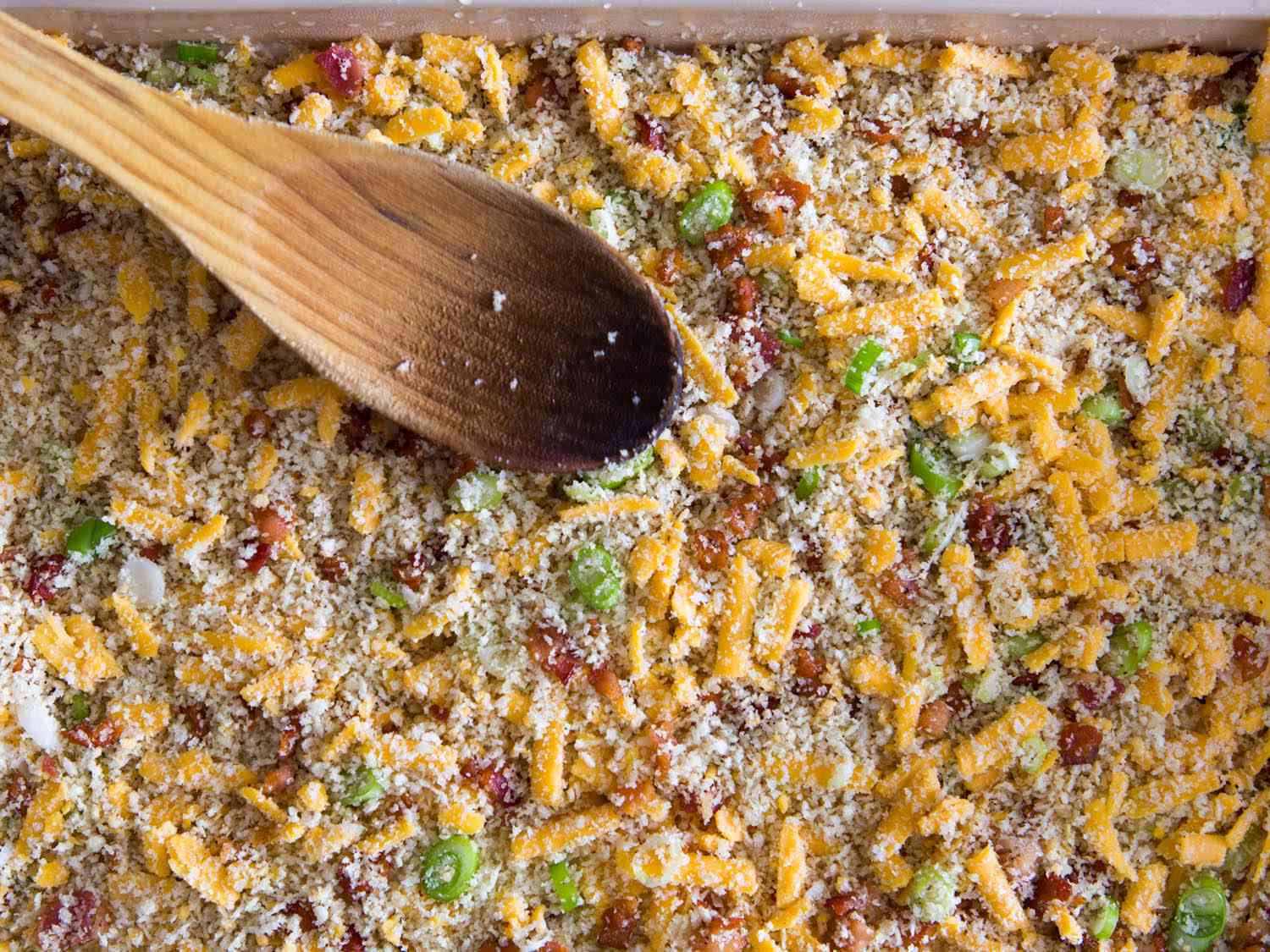 Spreading topping out evenly with back of wooden spoon.