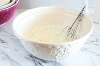 Creamy mixture in a Mason Cash bowl with a hand mixer