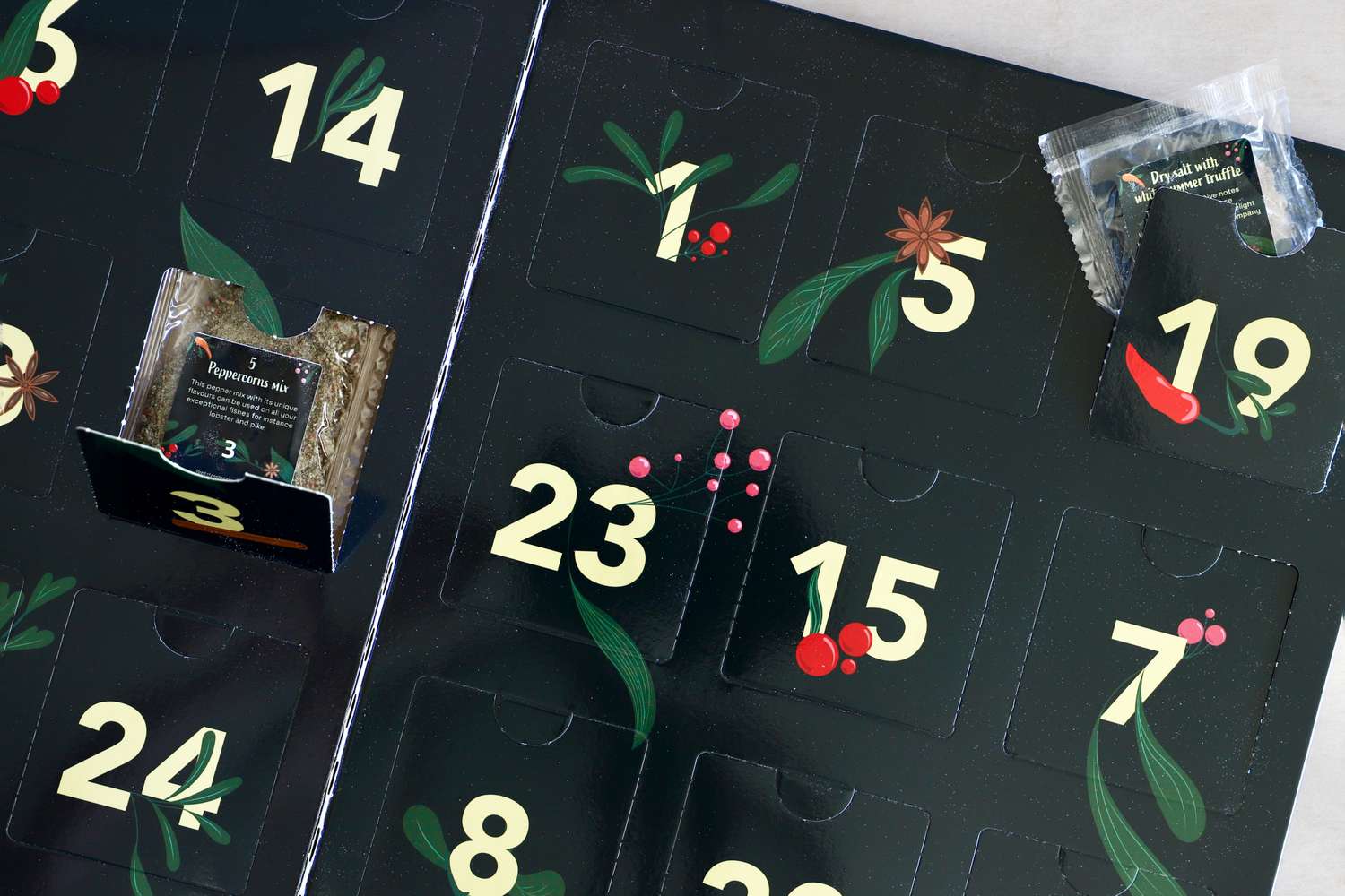 A spicethemed advent calendar with numbered slots one opened to reveal a seasoning packet