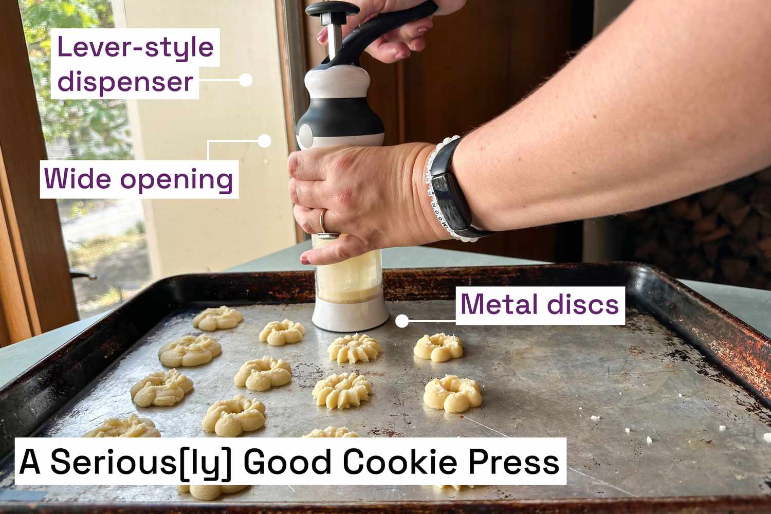 A person using a cookie press to make spritz cookies