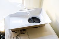 Water being added to the water reservoir of a countertop dishwasher.