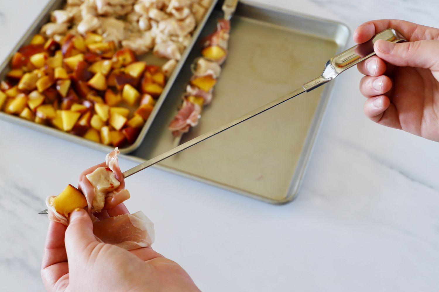 threading ingredients onto a stainless steel skewer