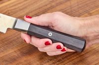 A person holds the handle on the Miyabi Koh 9.5 Inch Slicing Knife