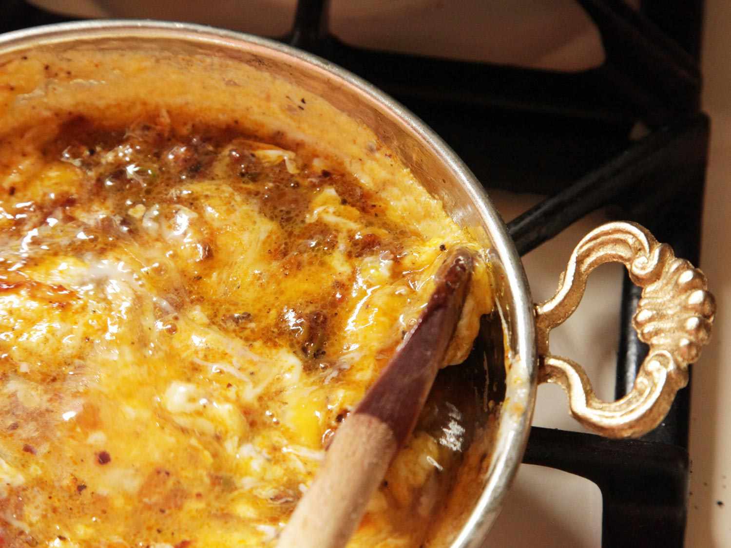 Gently scraping up beaten eggs from the edges of menemen 