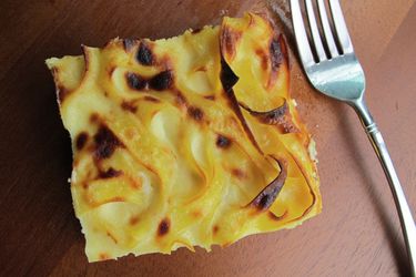 Overhead closeup of a square slice of white chocolate noodle pudding