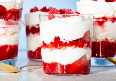 Eton mess desserts in glasses, layered with cream and strawberries