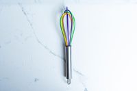 Kuhn Rikon Silicone Rainbow Whisk on a marbled surface