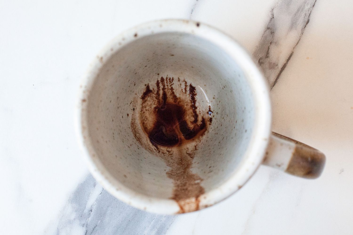 A top down view of a coffee mug after the coffee had been drank
