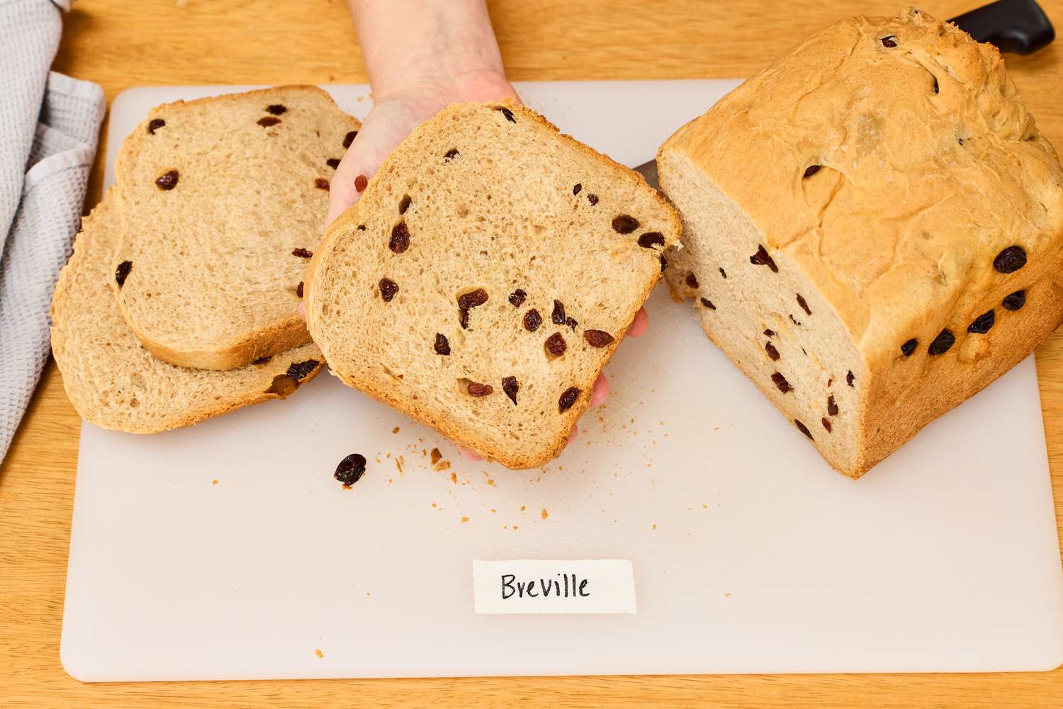Sliced raisin bread made in the Breville Custom Loaf Bread Maker on a cutting board