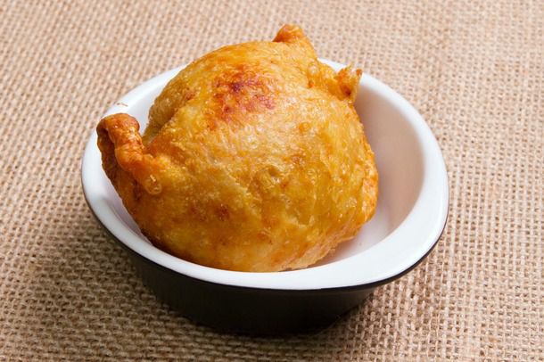 A single golden deep-fried matzo ball in a small dish