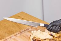 A person holds up the Miyabi Koh 9.5 Inch Slicing Knife