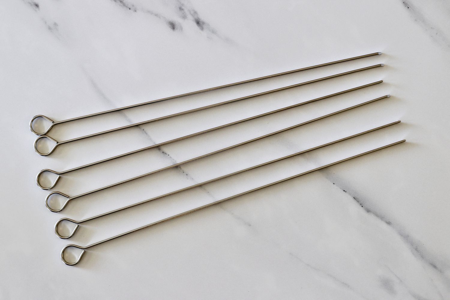 The Norpro metal skewers on a marble countertop.