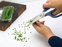 a person cutting chives with kitchen shears