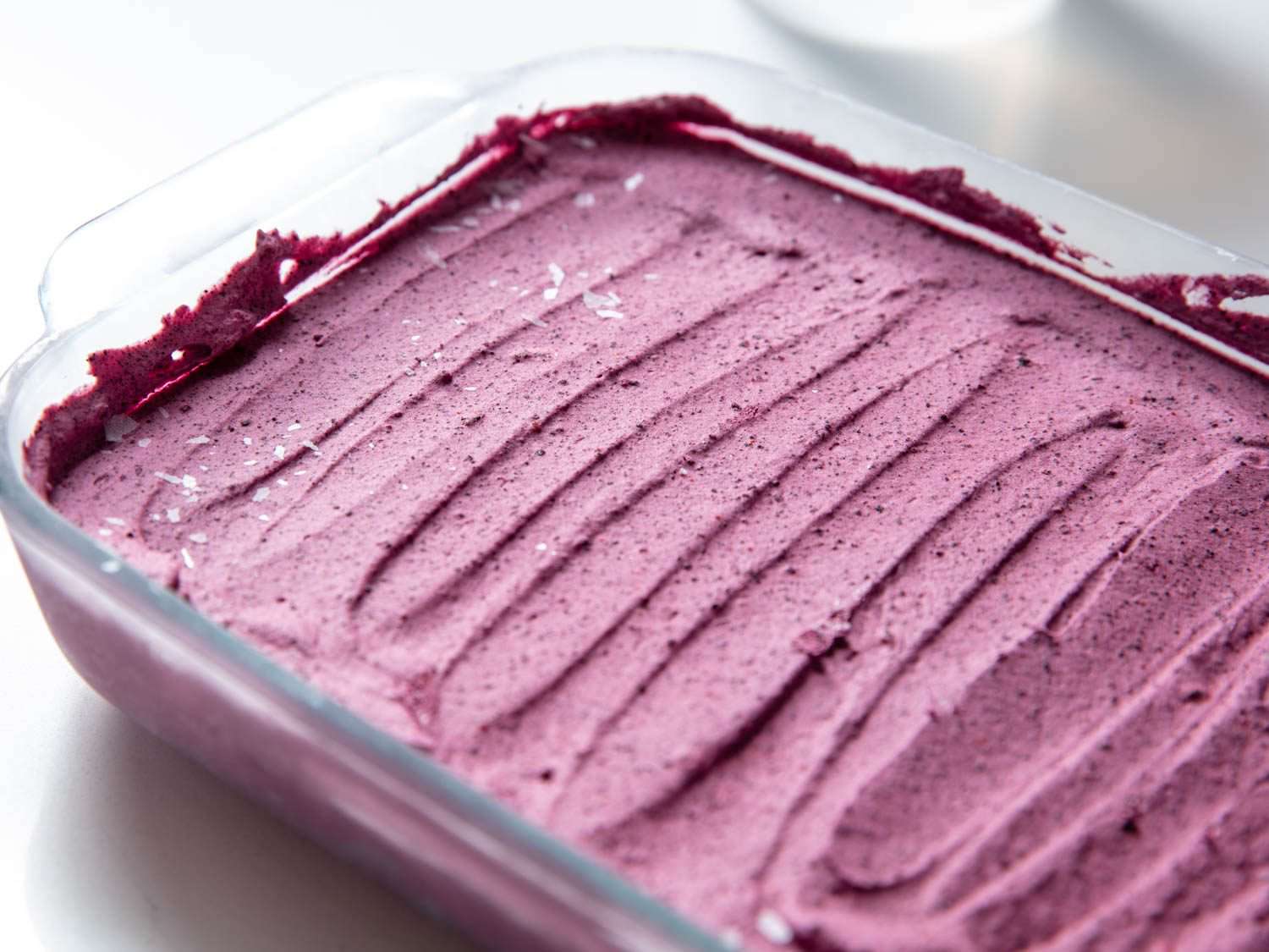 No-churn blueberry ice cream spread out in a glass baking dish