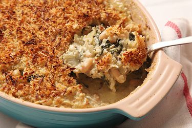Serving up a portion of Swiss chard, fennel, and white bean gratin